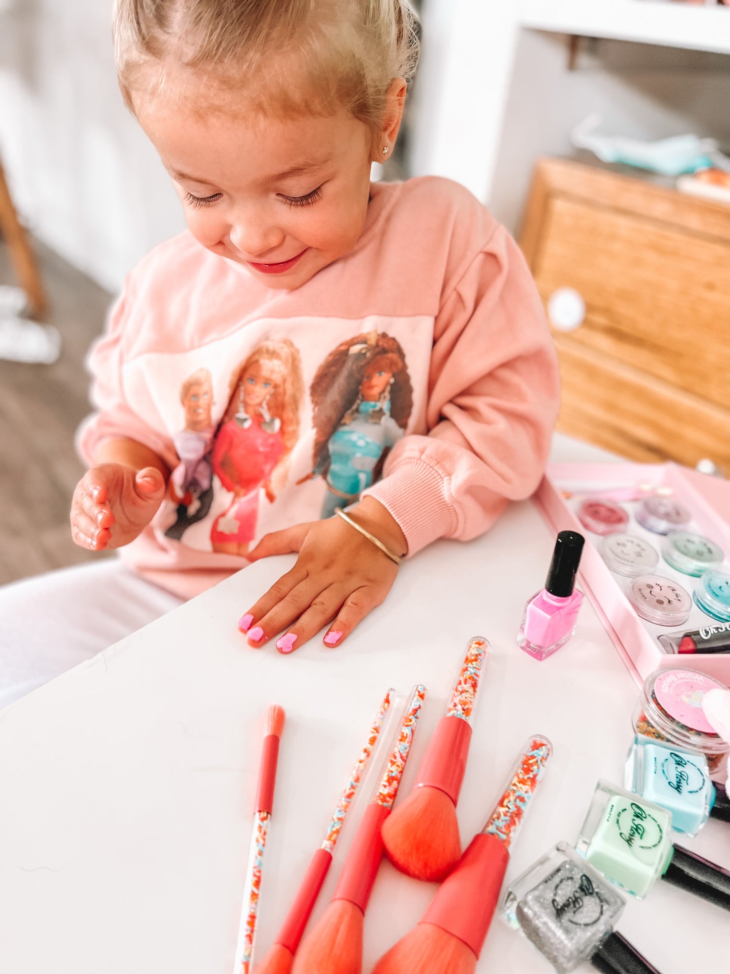 Little girl having a make up session with Oh flossy products