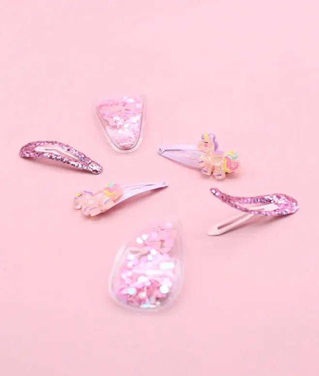 Set of colorful hair clips on a pink background