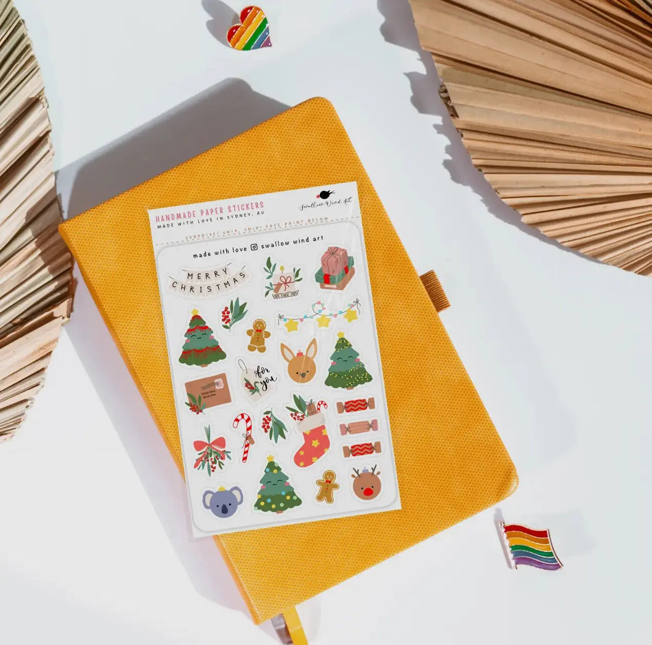 Sheet of Christmas-themed stickers on a yellow notebook with decorative elements.