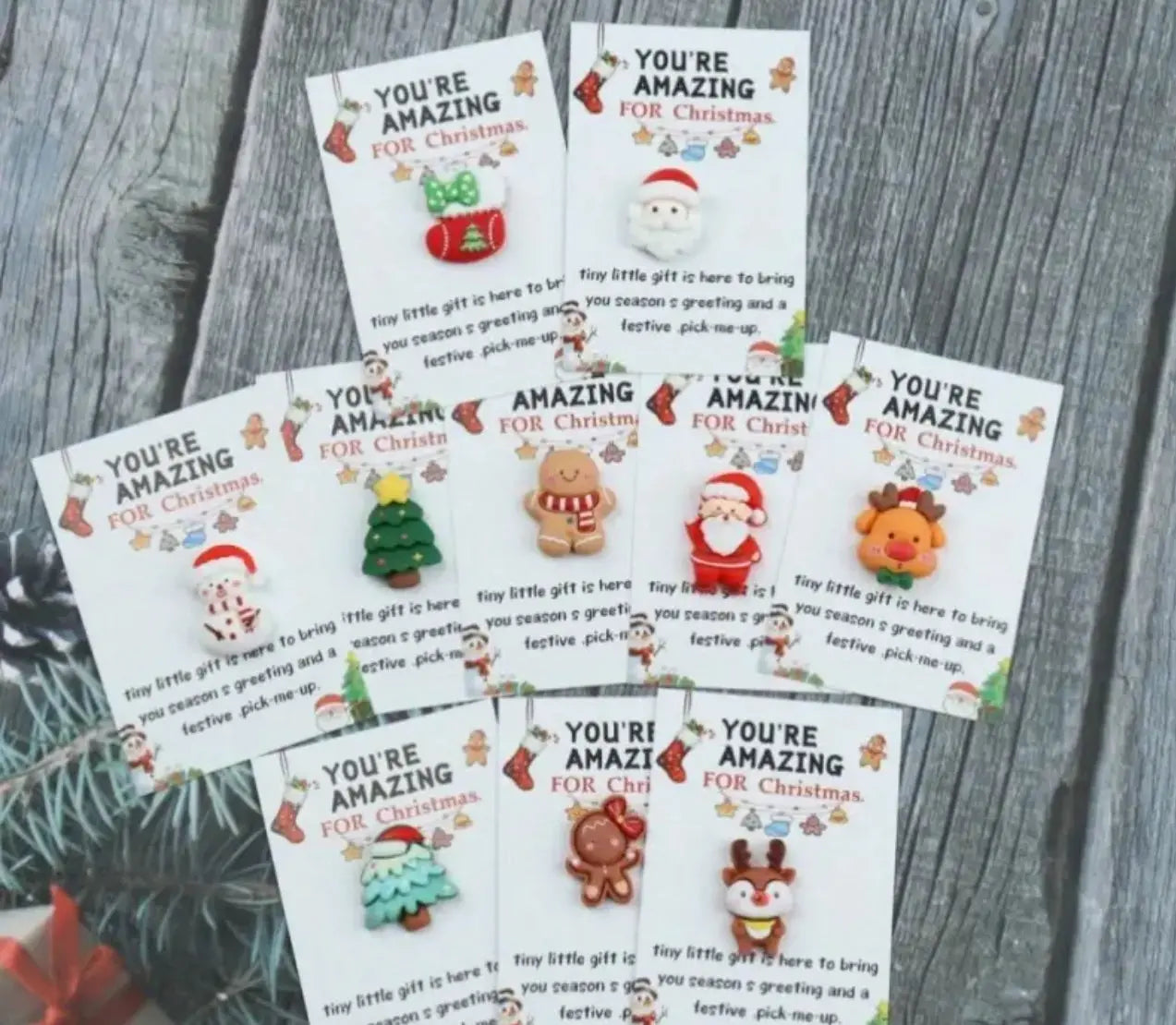 Set of 'You're Amazing For Christmas' cards with various designs on a wooden surface.