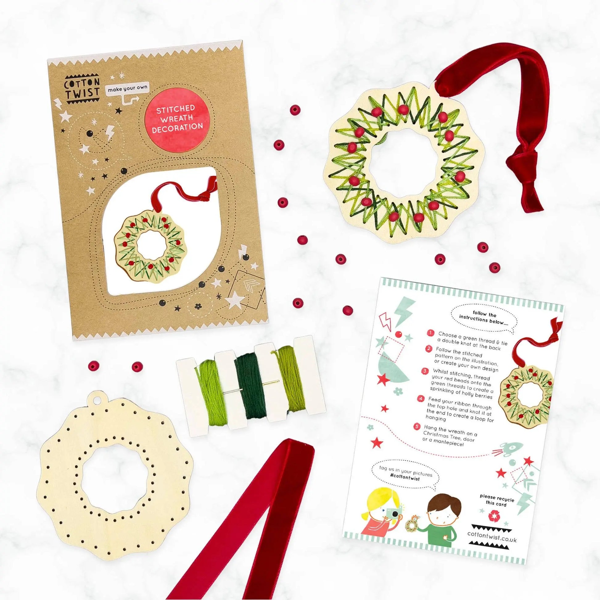 Craft kit with wreath decorations, ribbons, and instructions on a white background